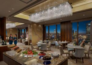 a restaurant with tables and chairs and a chandelier at Shangri-La Tianjin in Tianjin