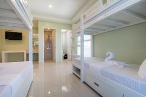
a bedroom with a white bed and white walls at Shore Time Dormitel in Boracay
