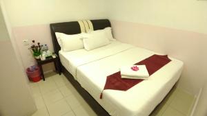 a hotel room with a bed with a box on it at Apple 1 Hotel Queensbay in Bayan Lepas
