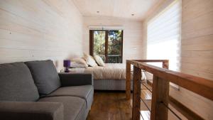 un soggiorno con un divano e un letto di Comarca Lodge a Pichilemu