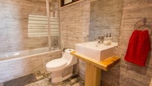 un bagno con lavandino, WC e vasca di Comarca Lodge a Pichilemu