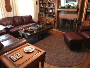 a living room with leather furniture and a fireplace at Casa Magnolia B & B in Saint Louis