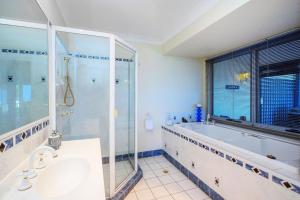 La salle de bains est pourvue d'une baignoire, d'un lavabo et d'une douche. dans l'établissement CLOUD 9 - Cliff Top Eagle Heights, à Mount Tamborine