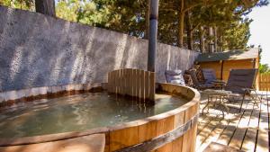 a small pool of water in a wooden tub at Comarca Lodge in Pichilemu