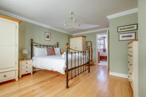 a bedroom with a bed and a chandelier at Tolly House in Wells next the Sea