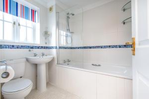 a bathroom with a toilet and a shower and a sink at Tolly House in Wells next the Sea