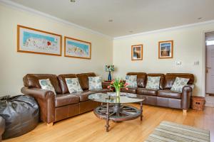 a living room with leather couches and a table at Tolly House in Wells next the Sea