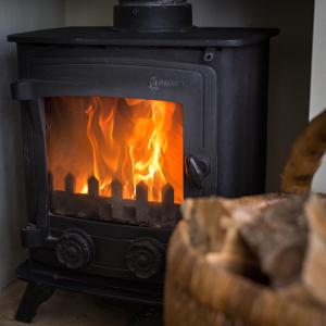 a black stove with a fire in it at Tolly House in Wells next the Sea