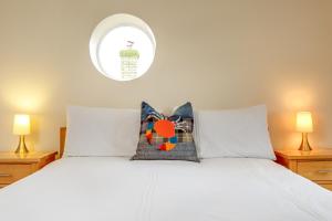 a bedroom with a white bed with two lamps at Tolly House in Wells next the Sea
