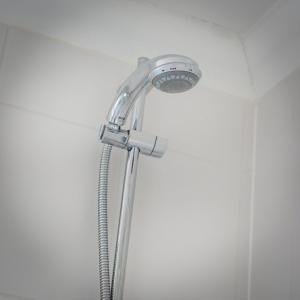 a shower with a shower head in a bathroom at Tolly House in Wells next the Sea