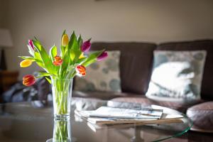 a vase of flowers sitting on a table at Tolly House in Wells next the Sea