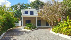 a white house with trees and plants in front of it at La Belle Créole in Las Galeras