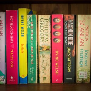 a row of books sitting on a shelf at Tolly House in Wells next the Sea
