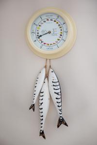 two fish hanging from a clock on a wall at Tolly House in Wells next the Sea