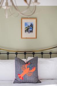 a bed with a pillow with a bird painted on it at Tolly House in Wells next the Sea