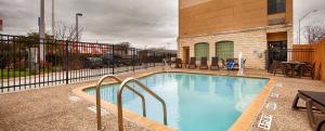 a swimming pool with a child sitting in a chair next to a building at Best Western Windsor Pointe Hotel & Suites - AT&T Center in San Antonio