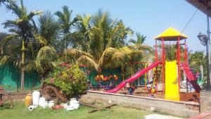 a childrens playground with a slide and a play equipment at Sea Land Kihim in Alibaug