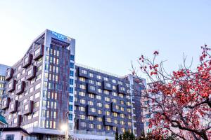 a tall building with a sign on top of it at The First70 Hotel in Seogwipo