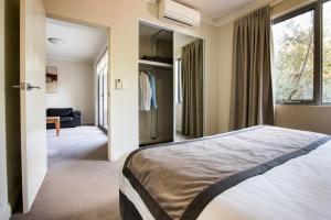 een slaapkamer met een groot bed en een raam bij Zappeion Apartments in Perth +45 foto's