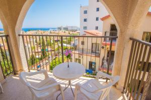 a balcony with a table and chairs and the ocean at Windmills Hotel Apartments in Protaras