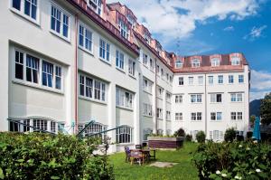 a row of white buildings with a table and chairs at myNext - Riverside Hotel Salzburg in Salzburg