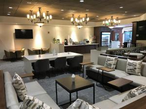 a lobby with couches and tables and a restaurant at Medallion Inn and Suites in Arlington