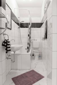 a white bathroom with a sink and a toilet at Ferienwohnung in Witten