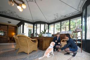 two women and a dog in a living room at Villa Sofia Hotel in Gardone Riviera