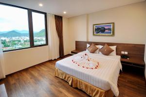 a bedroom with a bed with a large window at Lenid Ocean View Hotel in Nha Trang