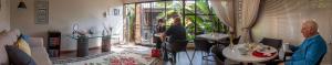 two people standing in a living room with a plant at Rest-a-While Guest House - Pretoria in Pretoria