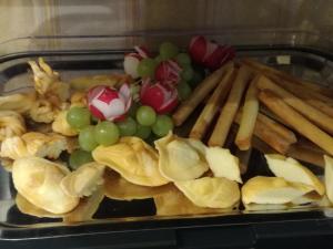 a tray of food with grapes and french fries at Pensjonat Gaborek in Krynica Zdrój