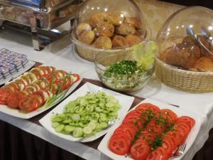 une table avec des plaques de légumes et d’autres denrées alimentaires dans l'établissement Pensjonat Gaborek, à Krynica-Zdrój