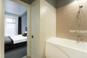 a bathroom with a bath tub and a bedroom at Sokroma Wow in Saint Petersburg