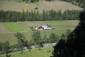 ein Haus mitten auf einem grünen Feld in der Unterkunft Apart Armin in Längenfeld