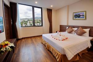 a hotel room with a bed and a large window at Lenid Ocean View Hotel in Nha Trang