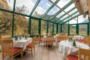 ein Restaurant mit Tischen und Stühlen in einem Wintergarten in der Unterkunft Seiterhof in Schladming