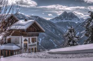 a house in the mountains with snow on it at Herol - my mountain retreat in Luson