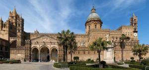 un grande edificio con una torre dell'orologio in cima di Dante 58 a Palermo