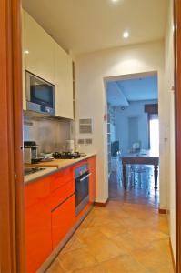 ヴェローナにあるCivico 95のキッチン(オレンジ色のキャビネット付)、ダイニングルーム(テーブル付)