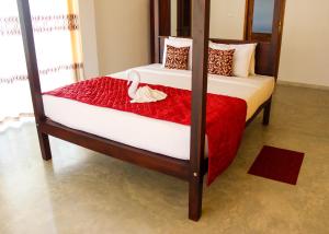 a bedroom with a bed with a swan on it at Villa Marina Hikkaduwa in Hikkaduwa