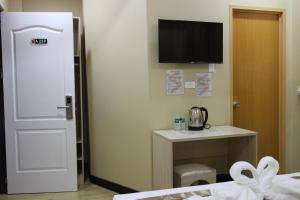 a room with a door and a desk and a television at Southview Hotel in Dumaguete