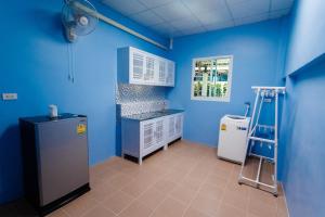 a blue kitchen with a sink and a refrigerator at P House in Kanchanaburi City