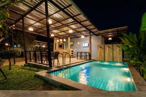 a swimming pool in a backyard at night at P House in Kanchanaburi City