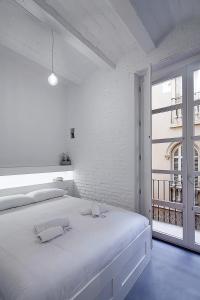 ein weißes Schlafzimmer mit einem großen Bett und einem Fenster in der Unterkunft Splendid houses in Valencia in Valencia