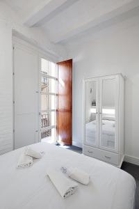 バレンシアにあるSplendid houses in Valenciaの白いベッドルーム(ベッド1台、タオル2枚付)