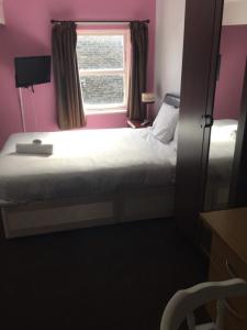 a small bedroom with a bed and a window at Gateway Lodge in Cleckheaton