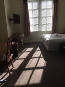 a bedroom with a bed and a window and a desk at Gateway Lodge in Cleckheaton