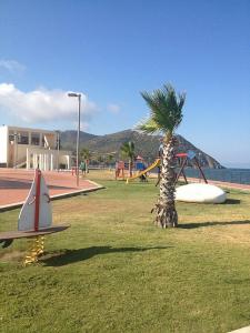 a park with a palm tree and a playground at Dolce Bungalow R5915 in Pula