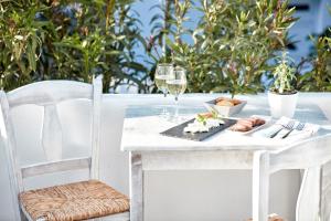a table with glasses of wine and food on it at Mykonos Town Suites in Mikonos