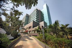 a walkway in front of a building with tall buildings at Gokulam Grand Hotel & Spa Bangalore in Bangalore